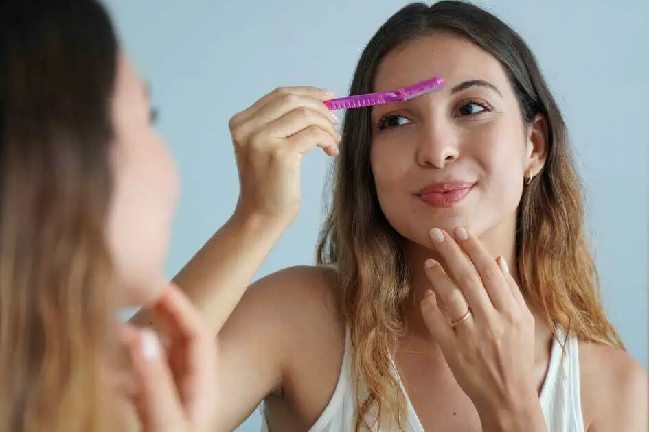 A woman brushing her eyebrows with Dermaplaning in Cary, NC